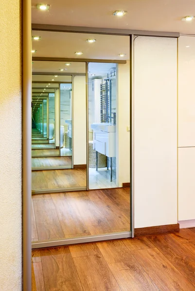 Sliding-door mirror wardrobe in modern hall interior with infini