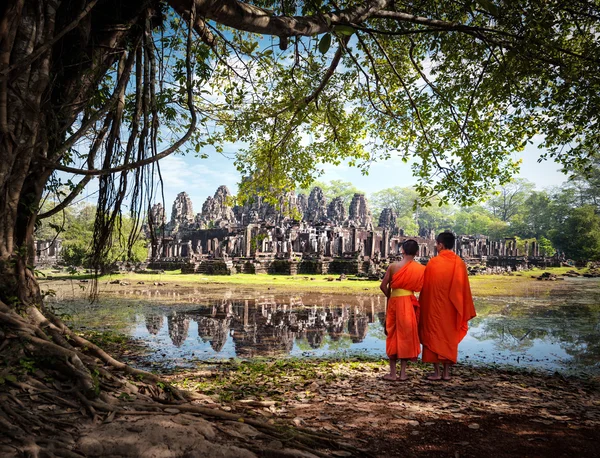 Two Angkor Wat monks near ancient Buddhist temple