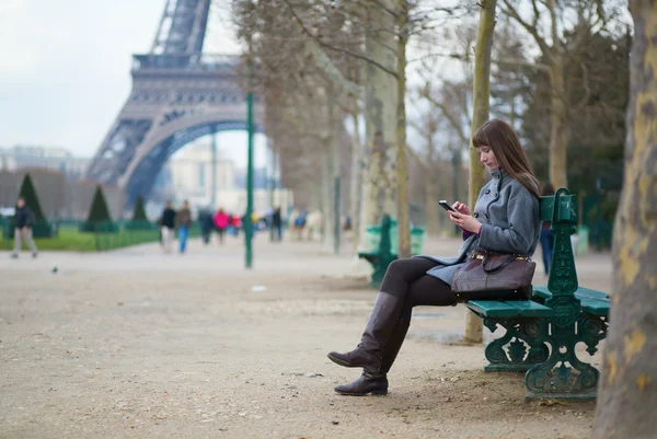Girl sending sms or surfing in the net in Paris