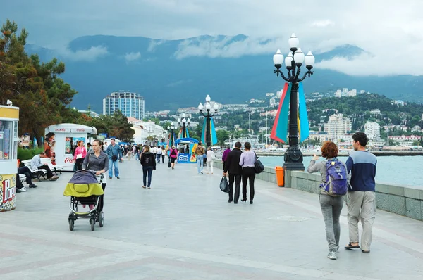 Tourists are walking along seafront of Yalta city, most famous ukrainian Black Sea resort