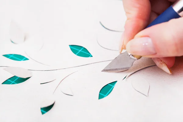 Woman's hand cutting out flower