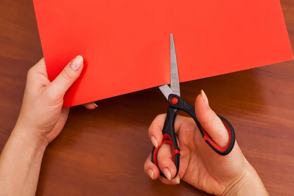 Woman's hand cutting paper
