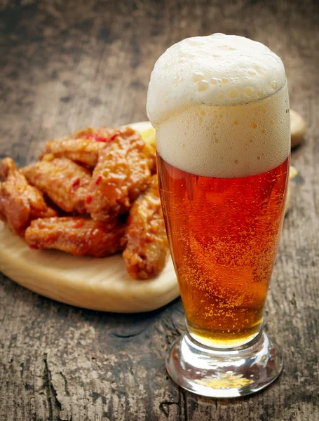 Glass of fresh beer and fried chicken wings