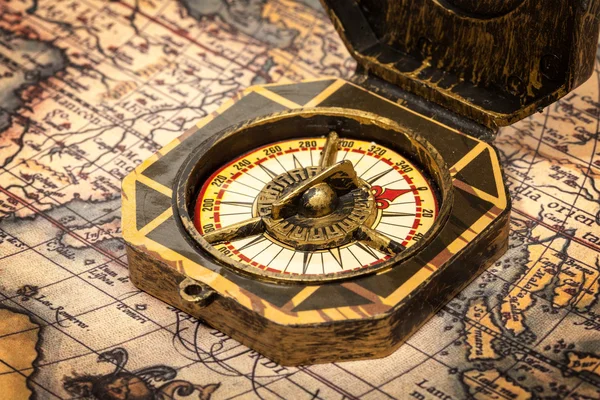 Vintage pirate compass on ancient map