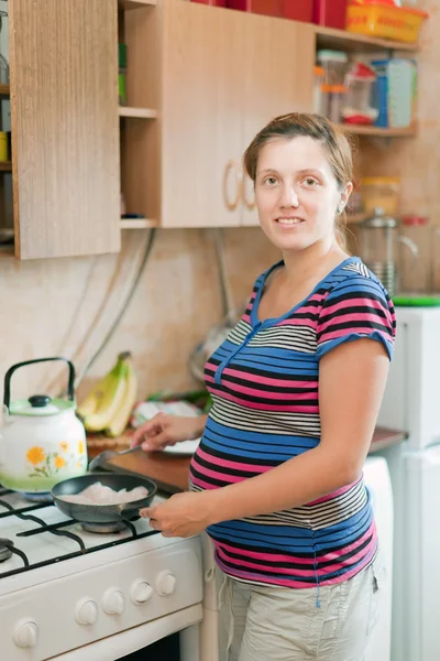 Pregnant woman cooks in the pan
