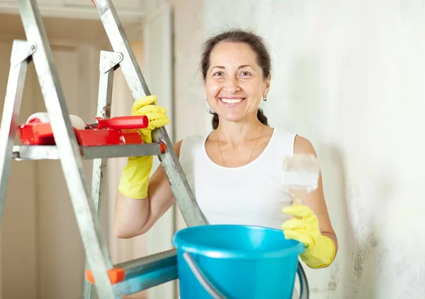 Woman makes repairs in apartment