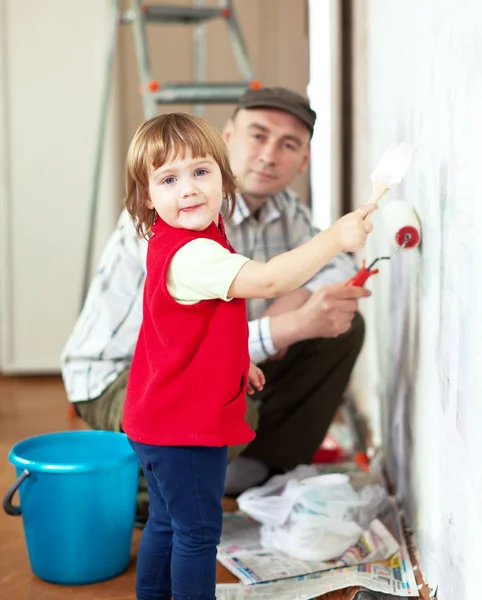Child with father paints wall