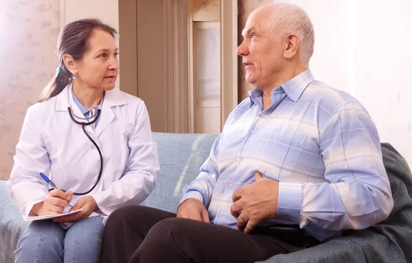 Mature man complaining to doctor about tummy-ache