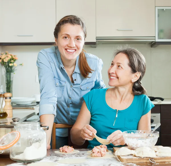 Women making pies or meat dumplings together