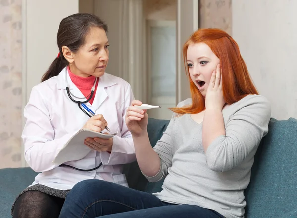 Mature doctor examining teenager patient