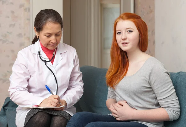 Girl complaining to doctor about tummy-ache