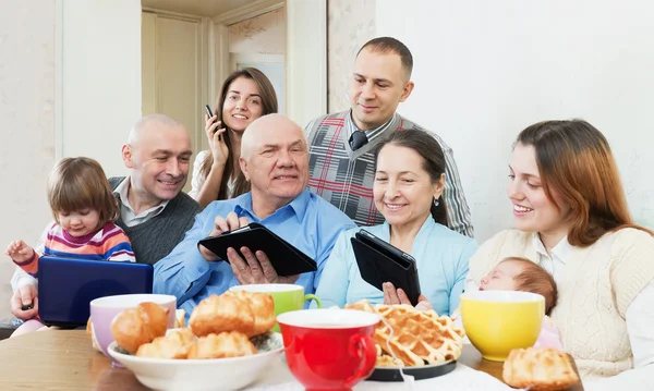 Happy family or friends with electronic devices
