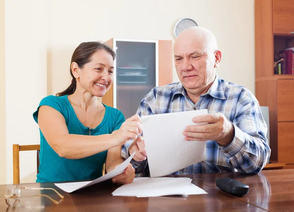 Man with pensive mature wife fills in questionnaire