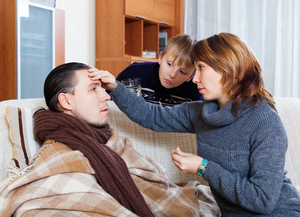 Woman and son caring for unwell man