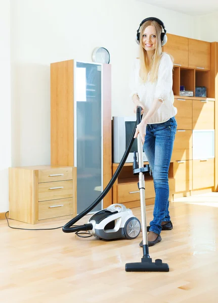Woman in headphones with vacuum cleaner