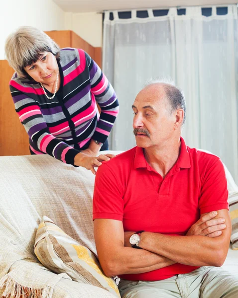 Mature couple after quarrel in living room