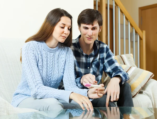 Serious couple with pregnancy test