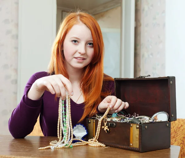 Teen girl chooses jewelry in treasure chest
