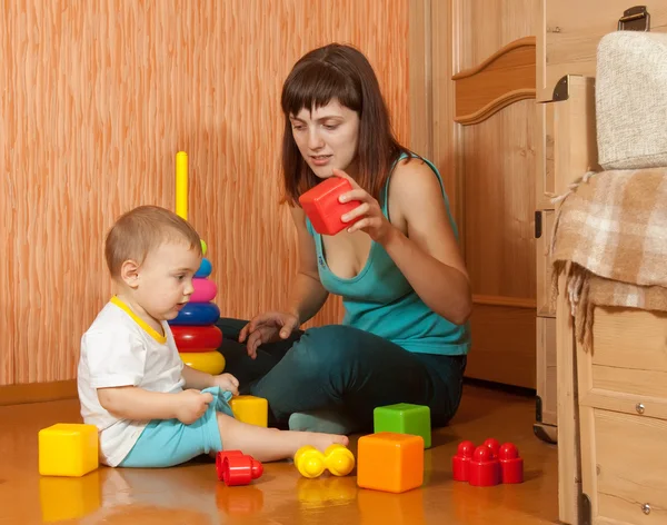 Mother and baby plays with toy blocks