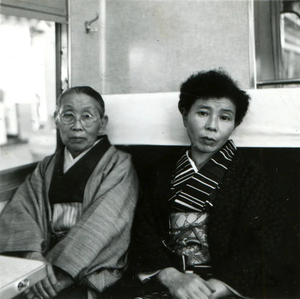 Two women in kimono in a train