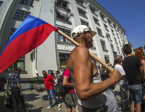 A man holds a flag of the self-proclaimed Luhansk republic