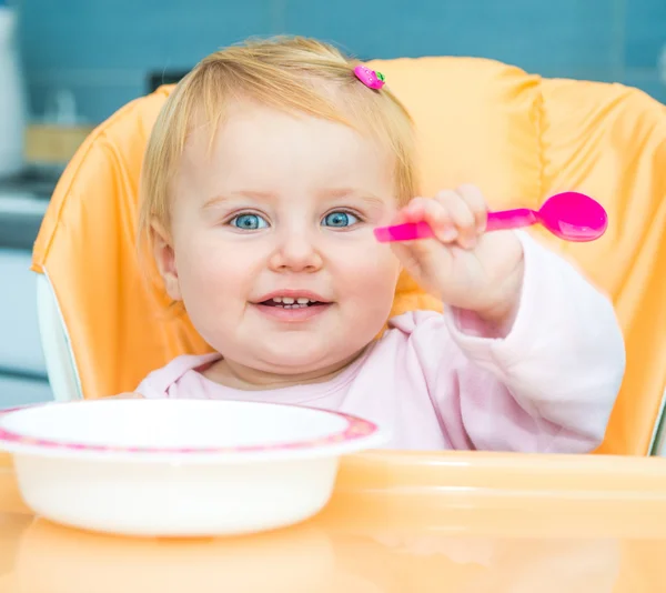 One year old girl in a highchair for feeding