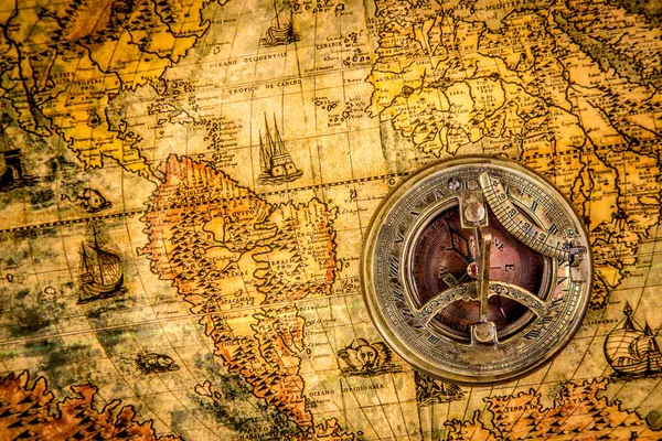 Vintage compass lies on an ancient world map