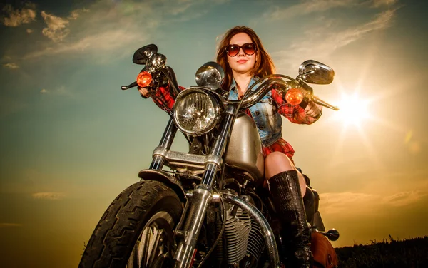 Biker girl sitting on motorcycle