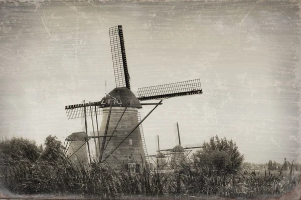Beautiful rural landscape with windmills in Kinderdijk, Holland (stylization under an old card)