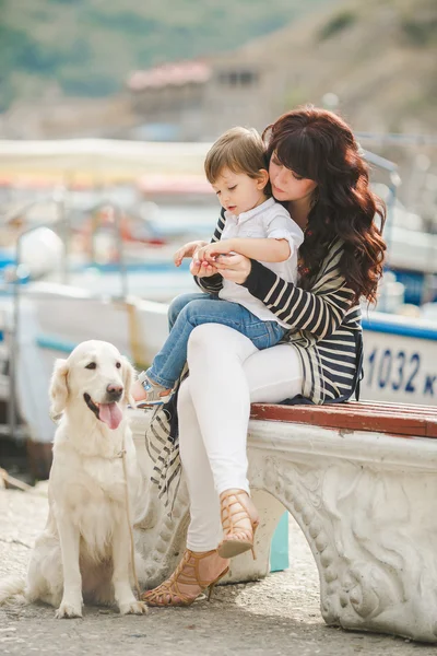 Mother and son on the waterfront with a dog