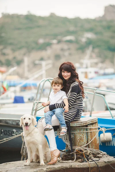 Mother and son on the waterfront with a dog