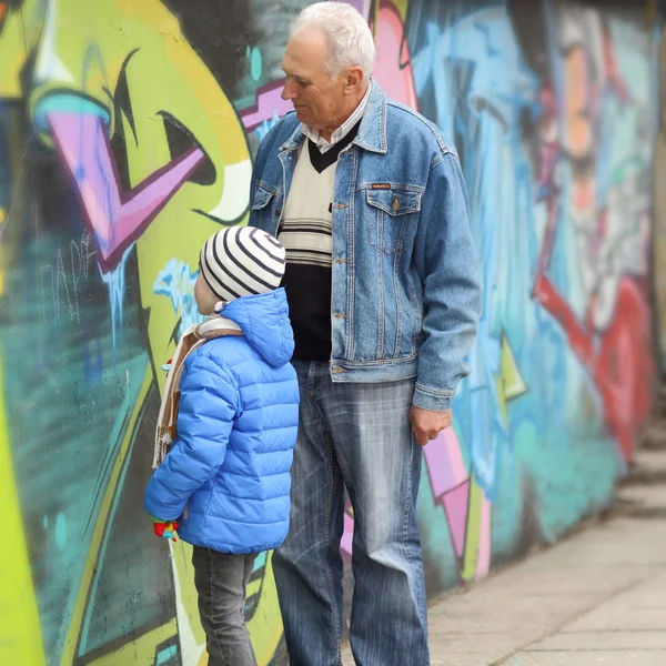 Grandfather and grandson paint graffiti
