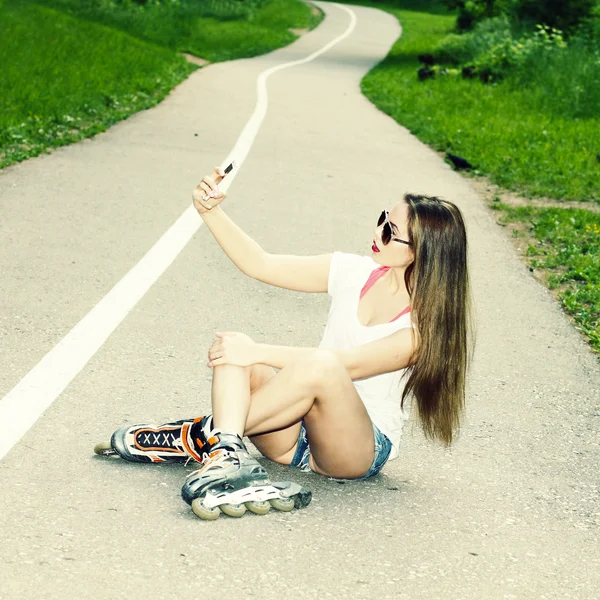 Girl on roller skates sitting on the road