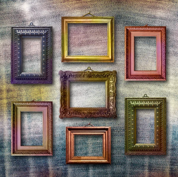 Gilded wooden frames for pictures on blue jeans background