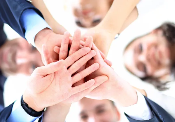 Small group of business people joining hands, low angle view.