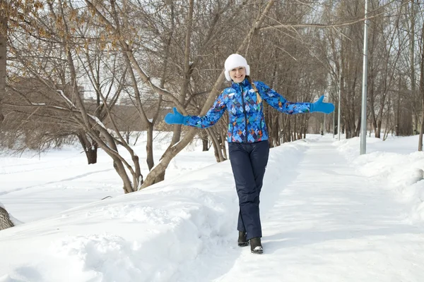 Happy woman walking in winter park
