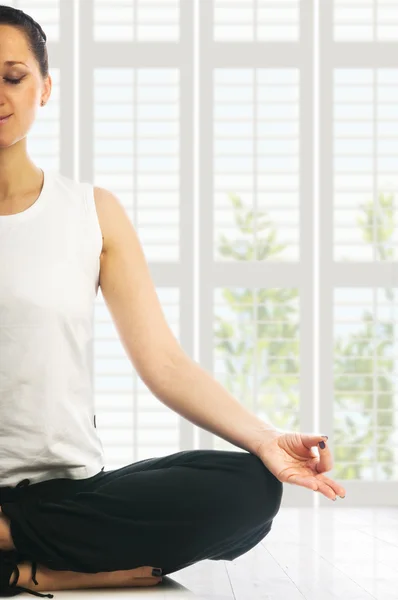 Woman in lotus yoga position making ohm mudra gesture