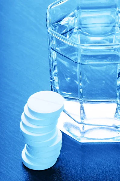 Aspirin pills and glass of water
