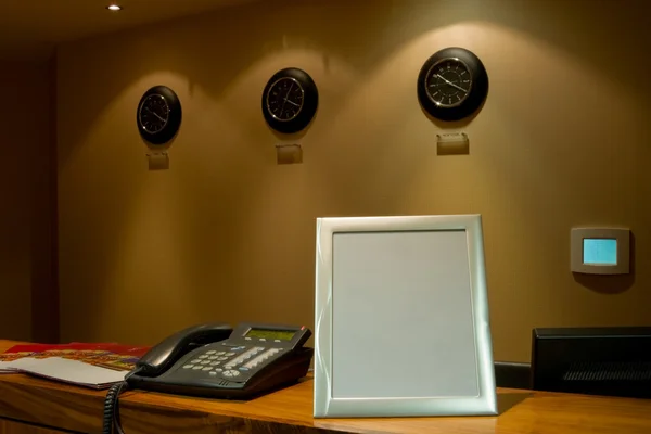 Reception desk with phone and row of clock