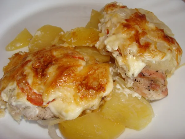Meat with pineapple slices, potatoes and cheese