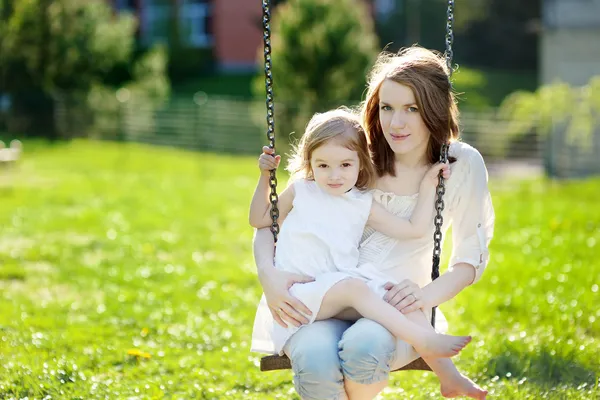 Mother and daughter on garden swing