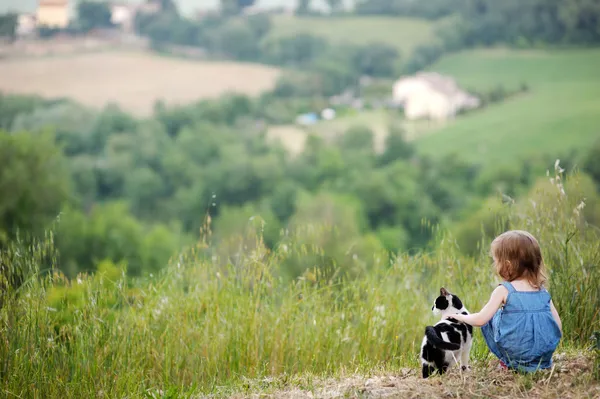 Adorable girl and a cat outdoors