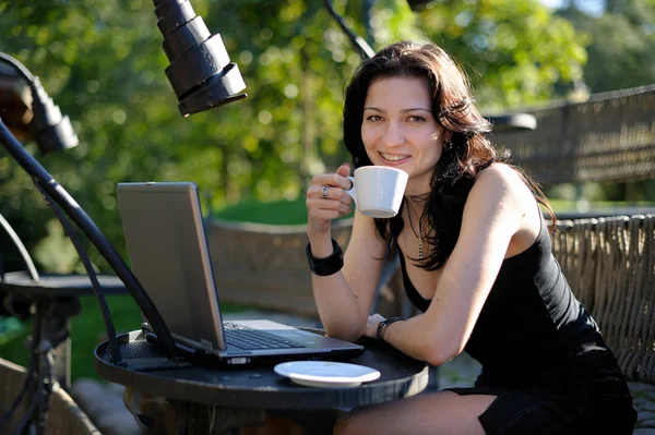 young lady with a notebook in a summer cafe