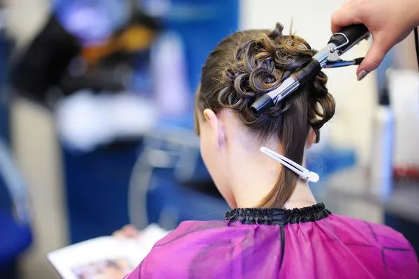 Woman's stylist's hands making a hairstyle