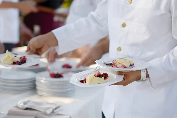 Waiter carrying plates with dessert