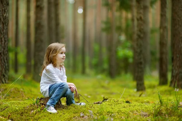 Adorable little girl hiking in the forest