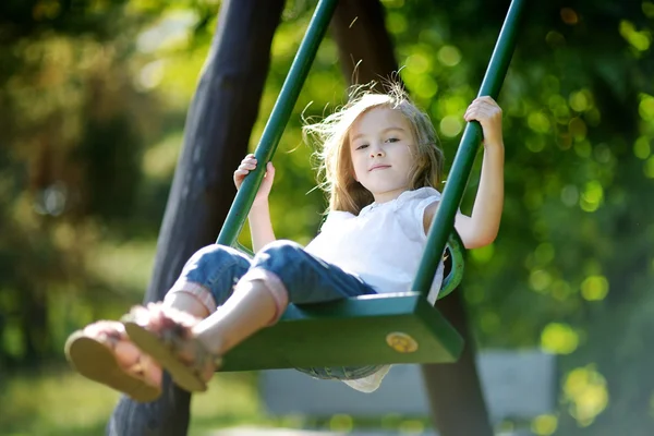 Adorable girl having fun on a swing