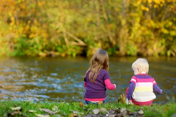 Two kids playing by a river