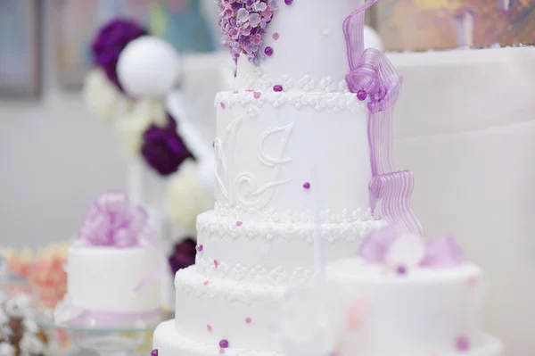 White wedding cake decorated with purple flowers