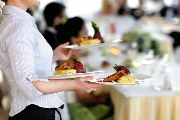 Waitress is carrying three plates